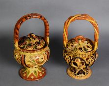 TWO SIMILAR TURKISH RED EARTHENWARE BASKET FORM COVERED STORAGE JARS, with applied simple floral