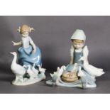 TWO LLADRO PORCELAIN GROUPS OF YOUNG GIRLS WITH WHITE GEESE AND GOSLINGS, one modelled standing, the