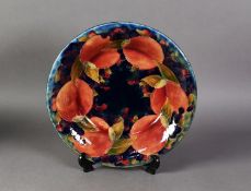 INTER-WAR YEARS WILLIAM MOORCROFT POTTERY SHALLOW DISH, decorated with pomegranates and berries on a