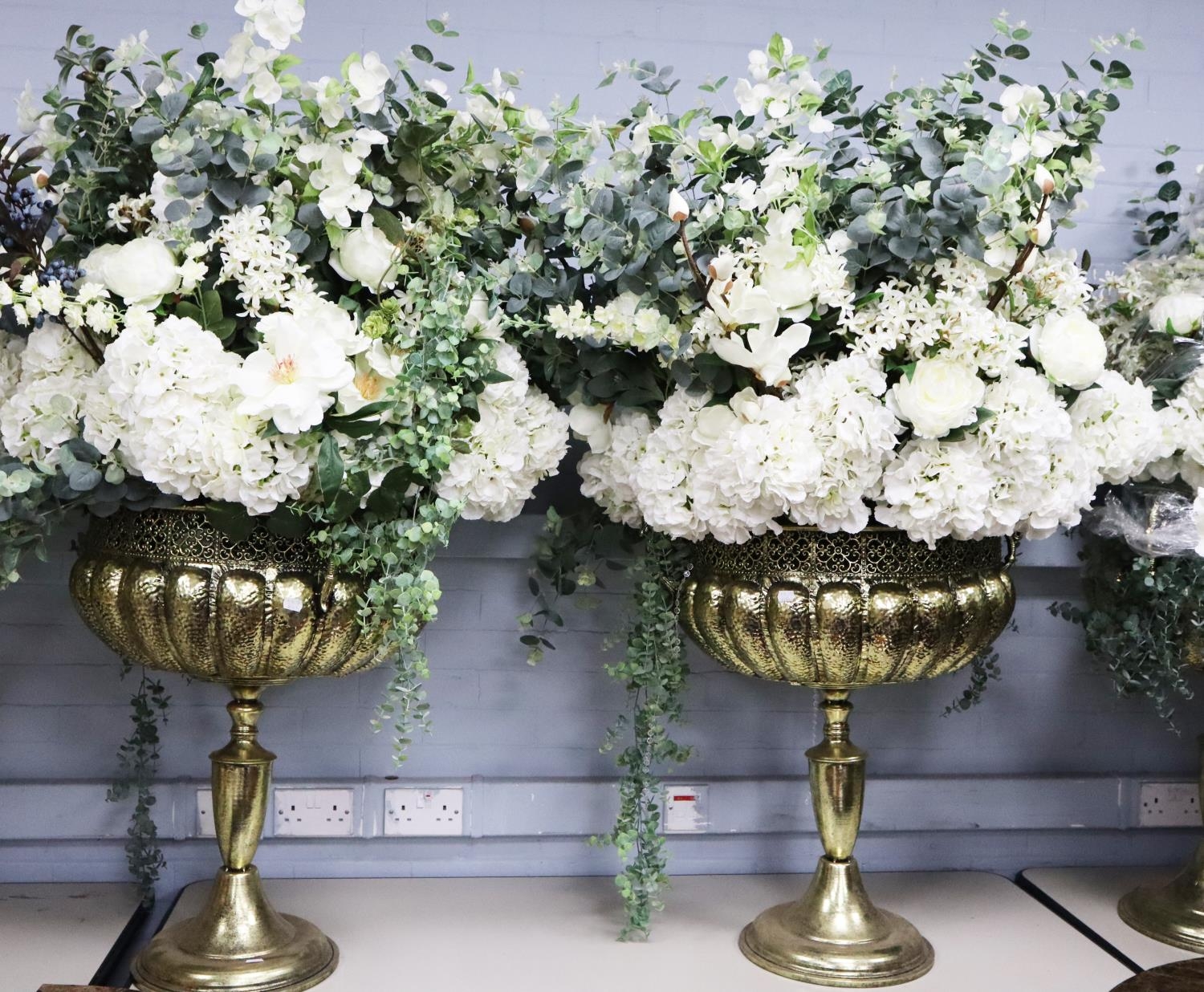 PAIR OF MODERN GILT METAL EFFECT TWO HANDLED PEDESTAL DRIED FLOWER VASES, each with pierced border