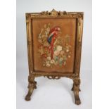 MOULDED GILT WOOD AND GESSO FIRE SCREEN, of picture frame form with woolwork centre depicting a