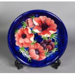 WALTER MOORCROFT ‘ANENOME’ PATTERN TUBE LINED POTTERY PLATE, painted in tones of red, purple and