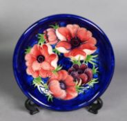 WALTER MOORCROFT ‘ANENOME’ PATTERN TUBE LINED POTTERY PLATE, painted in tones of red, purple and