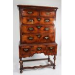 ANTIQUE FIGURED WALNUT CHEST ON STAND, the moulded cornice above two short and three long drawers