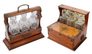 Two Edwardian brass bound oak three bottle tantalus