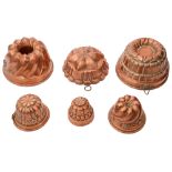 A collection of six copper jelly moulds