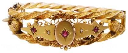 A Victorian 9ct gold Etruscan style ruby and diamond set bangle