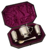 A late Victorian silver three piece cruet set in a fitted case