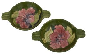 A pair of Moorcroft pottery hibiscus pattern shallow twin handled dishes