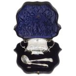 An Edwardian cased silver twin handled sugar bowl, sifter spoon and sugar tongs