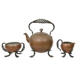 An Arts & Crafts plannished copper and wrought iron three piece tea service