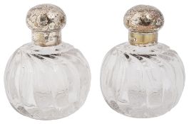 A pair of late Victorian silver topped cut glass scent bottles