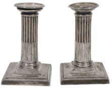 A pair of Edwardian silver dwarf stop fluted column candlesticks