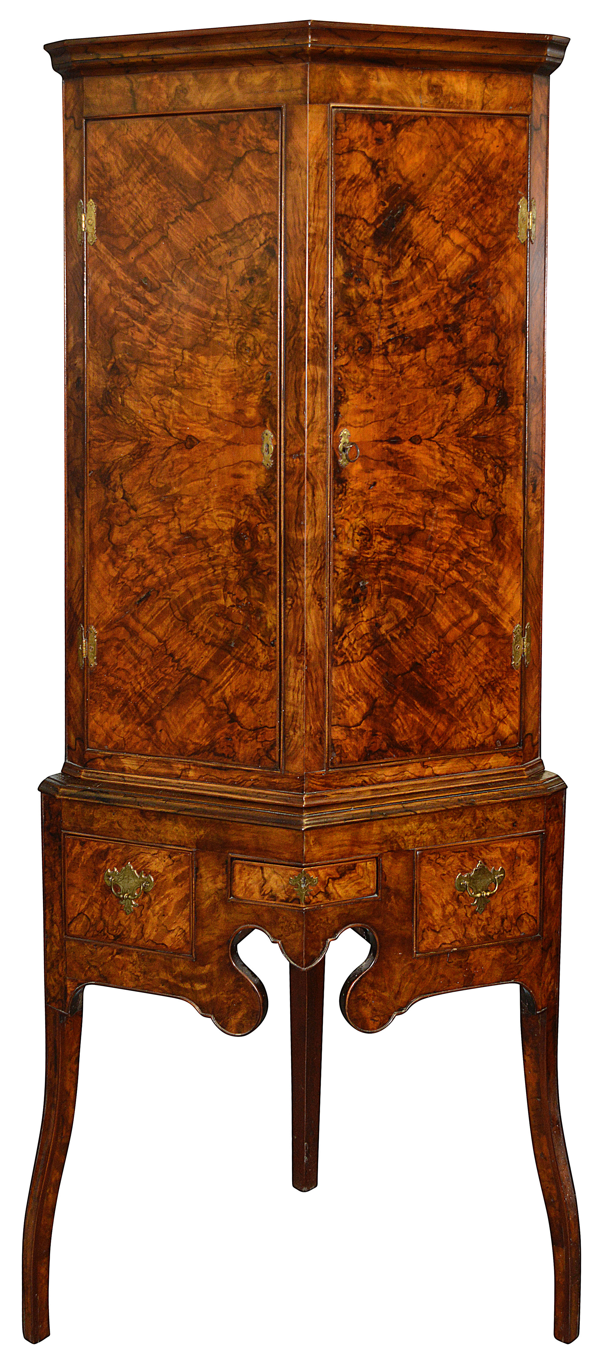 A George II burr walnut canted corner cupboard on stand