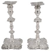 A near pair of George III cast silver candlesticks