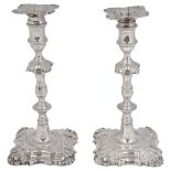 A near pair of George III cast silver candlesticks