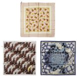 A collection of three designer scarves, including; Burberry and Cartier