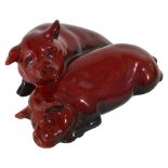 A Royal Doulton Flambe pair of recumbent pigs,