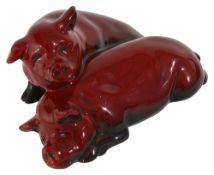 A Royal Doulton Flambe pair of recumbent pigs,