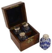 An early Victorian burr walnut cased set of silver topped scent bottles