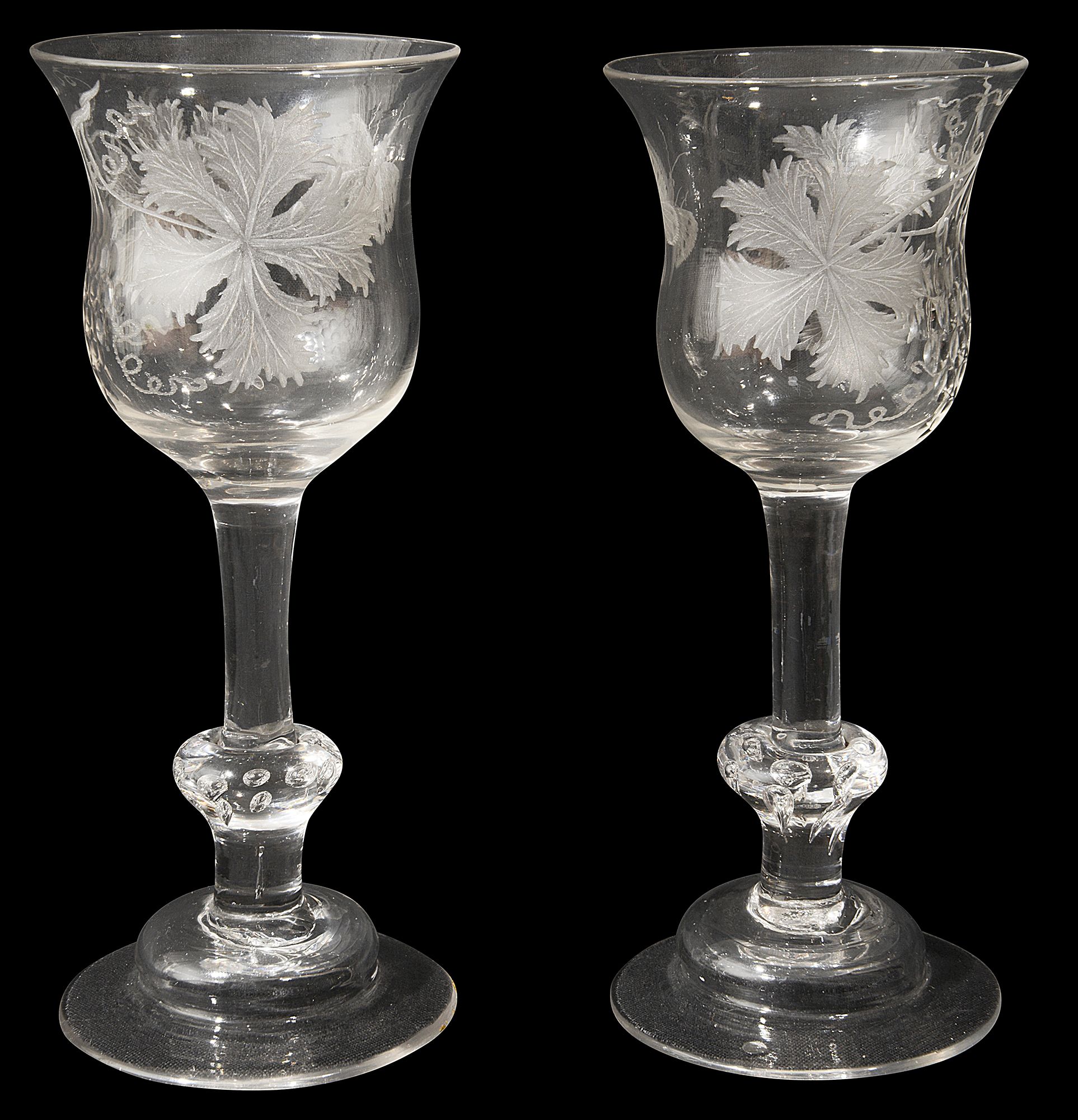 A pair of mid 18th century engraved composite stem wine glasses