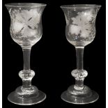 A pair of mid 18th century engraved composite stem wine glasses