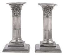 A pair of late Victorian silver dwarf Corinthian column candlesticks