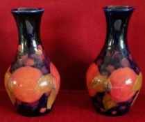 PAIR OF MOORCROFT GLAZED AND HANDPAINTED CERAMIC VASES DECORATED WITH FRUIT AND FOLIAGE,