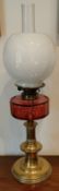 BRASS OIL LAMP WITH GLASS SHADE AND RED GLASS RESERVOIR, APPROXIMATELY 67cm HIGH REASONABLE