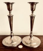 PAIR OF SILVER CANDLESTICKS WITH CIRCULAR BASE, CANDLESTICKS ARE FILLED