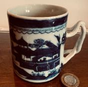 BLUE AND WHITE GLAZED TANKARD WITH CROSSOVER STRAP HANDLE, APPROXIMATELY 8.5cm HIGH