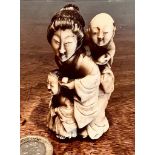 SMALL OKIMONO DEPICTING MOTHER AND CHILDREN IN IVORY, APPROXIMATELY 7cm HIGH