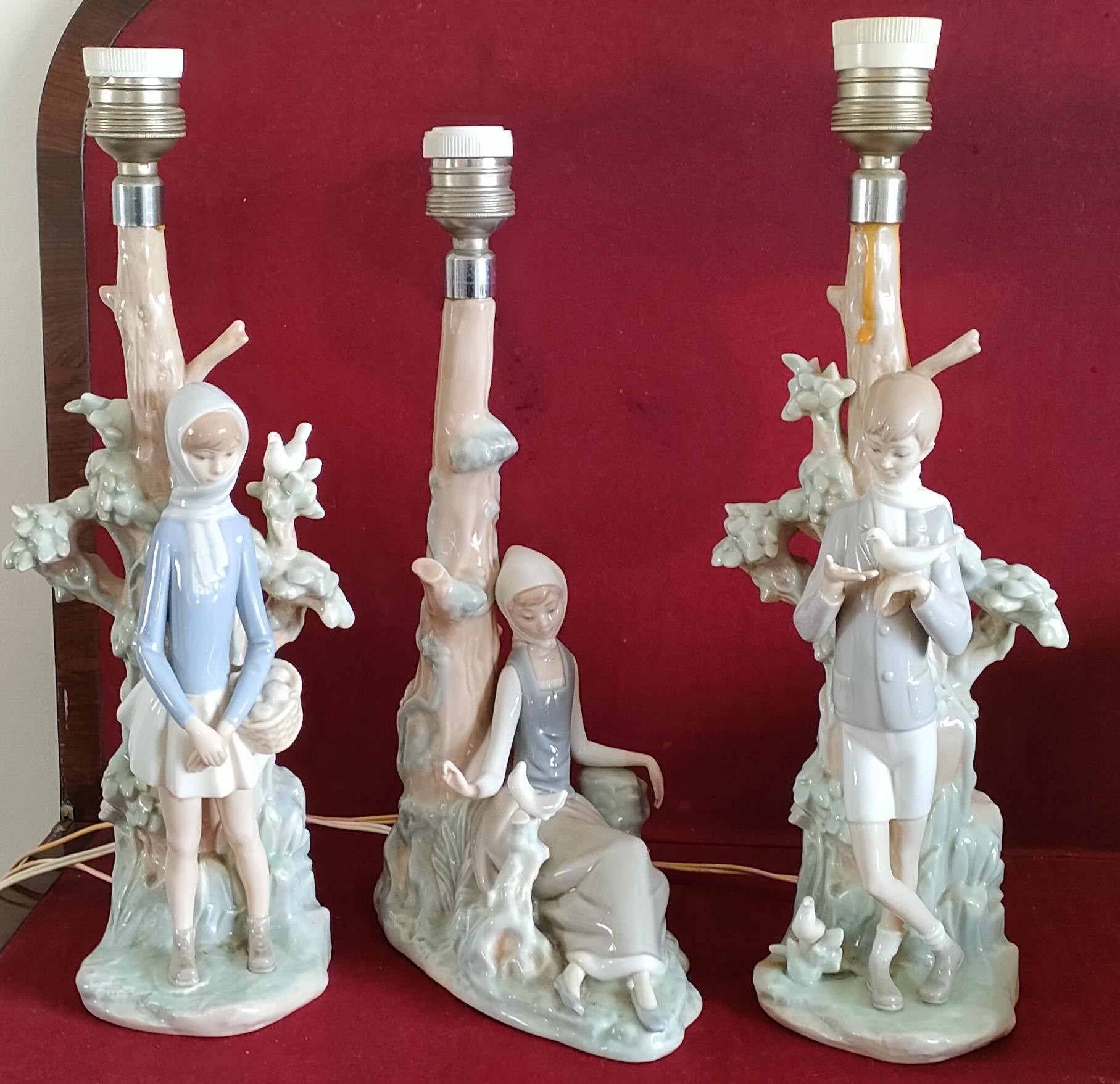 THREE VARIOUS GLAZED CERAMIC LLADRO TABLE LAMPS, DECORATED WITH FIGURES AND FOLIAGE ALL IN USED