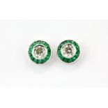 A pair of 18ct white gold stud earrings set with centre diamonds 0.52ct surrounded by emeralds, dia.