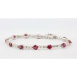 An 18ct white gold bracelet set with 1.74ct brilliant cut diamonds and 5.42ct of pear cut rubies, L.