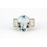 An 18ct white gold ring set with a large oval cut aquamarine, approx. 6.5ct, with baguette and