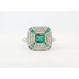 A lovely 18ct white gold art deco style emerald and diamond ring, setting L. 1.3cm, (N).