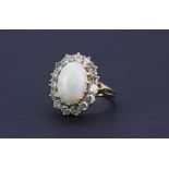 An 18ct yellow gold ( worn 750 mark ) cluster ring set with a large cabochon cut opal surrounded
