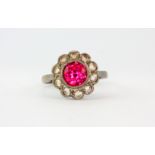 A 9ct and silver cluster ring set with a round synthetic ruby surrounded by diamonds, (M).