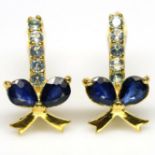 A pair of 925 silver gilt bow shaped earrings set with pear cut sapphires and white stones, L. 1.