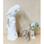 A Copenhagen B&G figure of a bird and chick, together with two porcelain figures of parrots, tallest