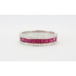 An 18ct white gold three row ruby and diamond half eternity ring, (P).