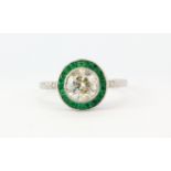 An 18ct white gold emerald and diamond ring set with a centre diamond approx. 1.07ct, (N).