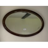 A 1920's oval mirror, W. 75cm.