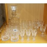 A cut glass decanter and a quantity of cut glass drinking glasses.