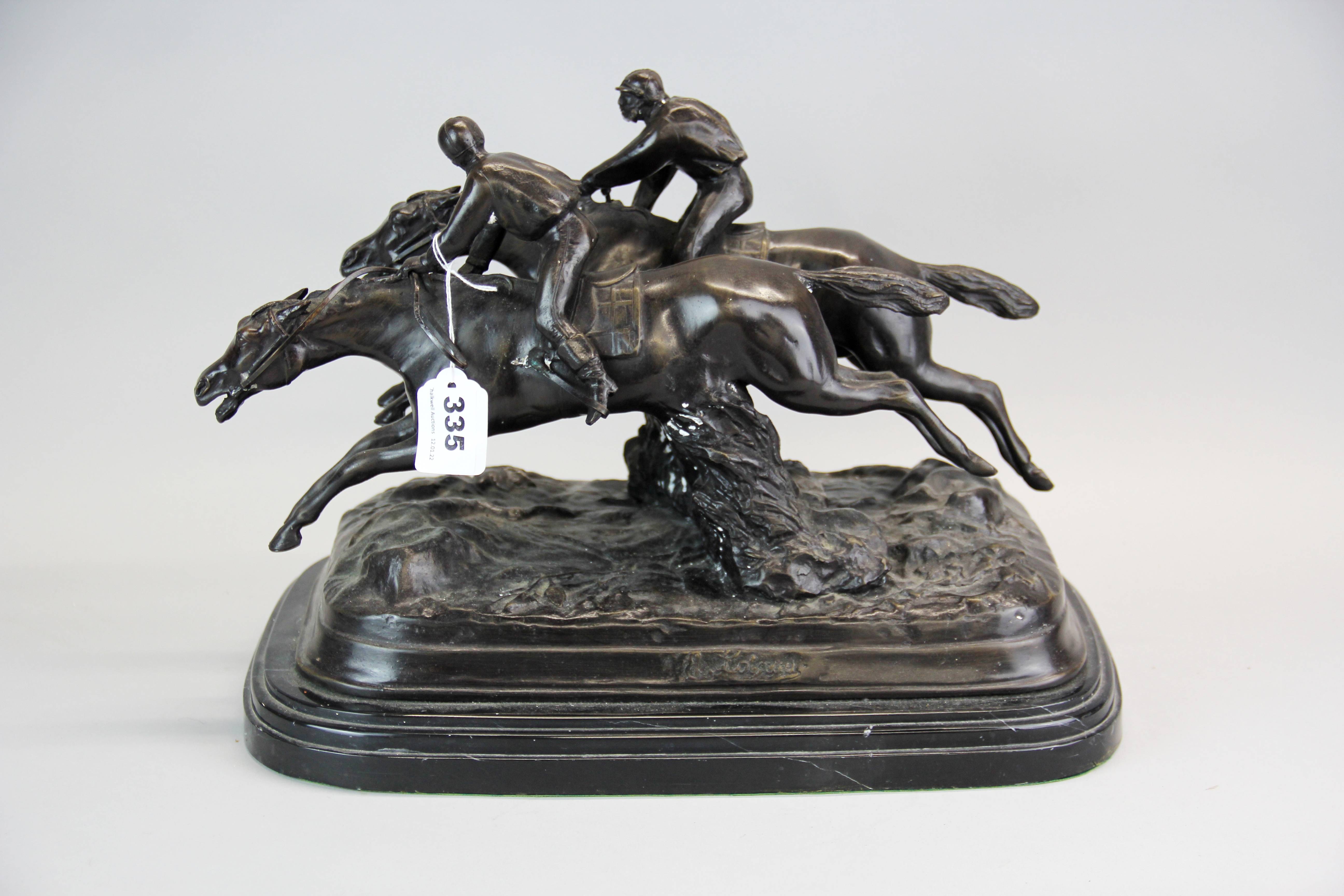 A cast bronze horseracing group figure on a marble base, H. 26cm, W. 42cm.