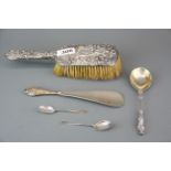 A hallmarked silver backed brush, shoehorn and three spoons.