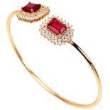 A 925 silver gilt bangle set with emerald cut rubies and white stones.