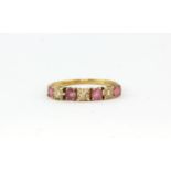 A hallmarked 9ct yellow gold ring set with round cut rubies and diamonds, (N).