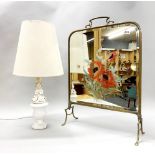 A Victorian brass fire screen and a ceramic lamp base.